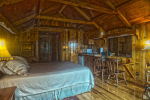 Adirondack style room with chairs, small kitchen and bed